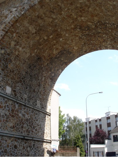Echappée sur l’immeuble près de la Forge à travers l’arcade qui a été bombardée en juin 1944. On note les renforts métalliques de la base et les raccords de maçonnerie de la voûte. Cliché J. Larour mai 2007 Echappée sur l’immeuble près de la Forge à travers l’arcade qui a été bombardée en juin 1944. On note les renforts métalliques de la base et les raccords de maçonnerie de la voûte. Cliché J. Larour mai 2007