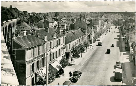 Une perspective de l’avenue originale, prise du haut des Arcades. On voit les arches de maonnerie allant en courbe jusqu’ tangenter la ligne rive droite. Au pied le magasin des cooprateurs. CP semi moderne, annes 1950.