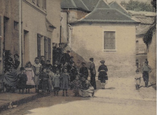 Dtail du groupe d’enfants. Devant la porte  gauche, on peut penser reconnatre la fillette et le garon prsents sur la vue en N/B. CPA colorie. Coll. part ;