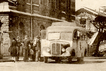 La monte dans l’autocar Gaubert. De dos, avec un baudrier et une casquette, le contrleur rgule la monte.