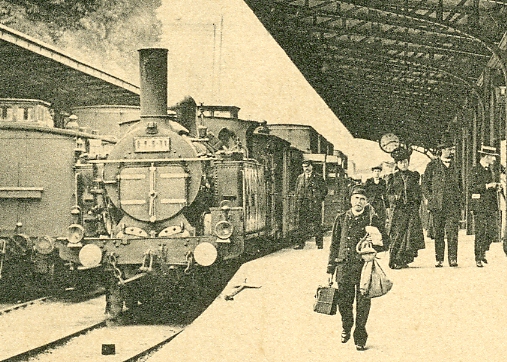 Détail de la vue précédente. Arrivé à 14h40, le train est encore tiré par une locomotive à vapeur. A côté d’elle un employé de quai en uniforme (est-ce le chef de gare ?). Au premier plan, un autre employé, probablment un coursier se chargeant des messageries. (coll. part) Détail de la vue précédente. Arrivé à 14h40, le train est encore tiré par une locomotive à vapeur. A côté d’elle un employé de quai en uniforme (est-ce le chef de gare ?). Au premier plan, un autre employé, probablment un coursier se chargeant des messageries. (coll. part)
