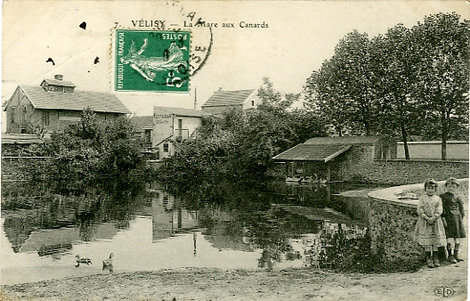 La mare aux canards. Petite animation avec enfants. On distingue, comme sur la vue suvante, des laveuses travaillant au lavoir. CPA circule. (coll. part.)