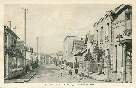 Vue anime de la rue du Parc. Cette rue est parallle  la route nationale. A noter l’unique point d’clairage public au croisement des rues. Le nombre d’enfants tmoigne de la vitalit du lotissement rcemment bti. CPM dos clair divis, circule, 1933.