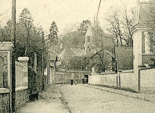 Dans l’axe, dtail du mur de l’Orangerie et du clocher de l’glise du Village.