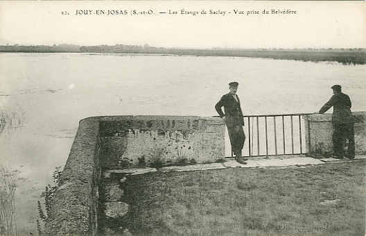 Point de vue sur la route passant au milieu des étangs de Saclay. Ce site est maintenant un point d’observation des oiseaux migrateurs. L’attitude des deux hommes peut laisser supposer qu’il l’était déjà il y a un siècle. (coll. part.) Point de vue sur la route passant au milieu des étangs de Saclay. Ce site est maintenant un point d’observation des oiseaux migrateurs. L’attitude des deux hommes peut laisser supposer qu’il l’était déjà il y a un siècle. (coll. part.)